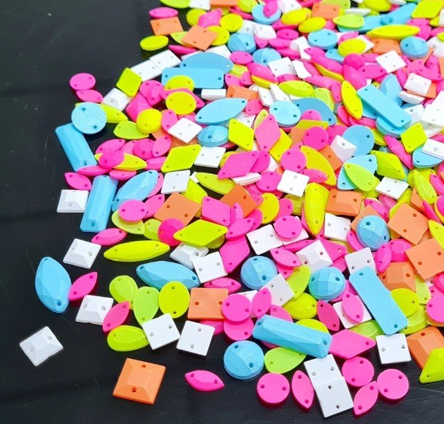 
Montão de chatons com furo de várias cores (verde, azul, branco, rosa e laranja) e formatos.