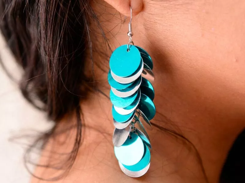 Brinco de disco azul e prateado em cabelo solto