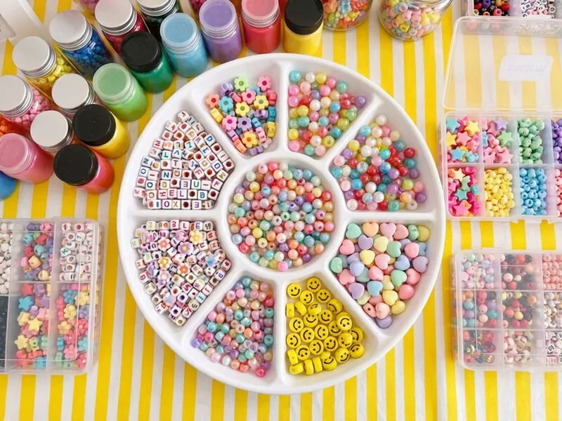 Criança sorridente mostrando pulseiras coloridas