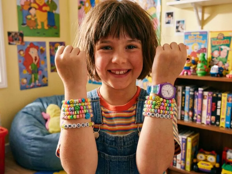 Mesa colorida com materiais para fazer bijuterias infantis.