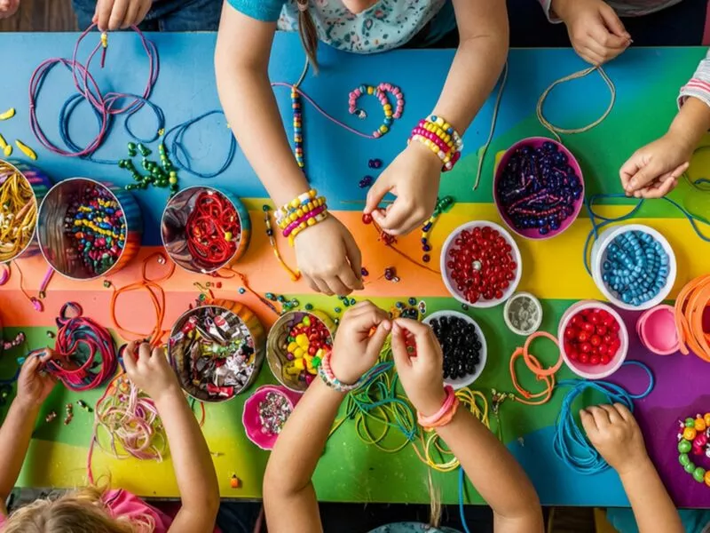 Crianças criando bijoux com miçangas coloridas