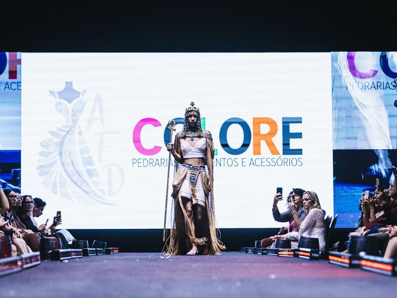 Modelo desfilando na passarela com traje extravagante.