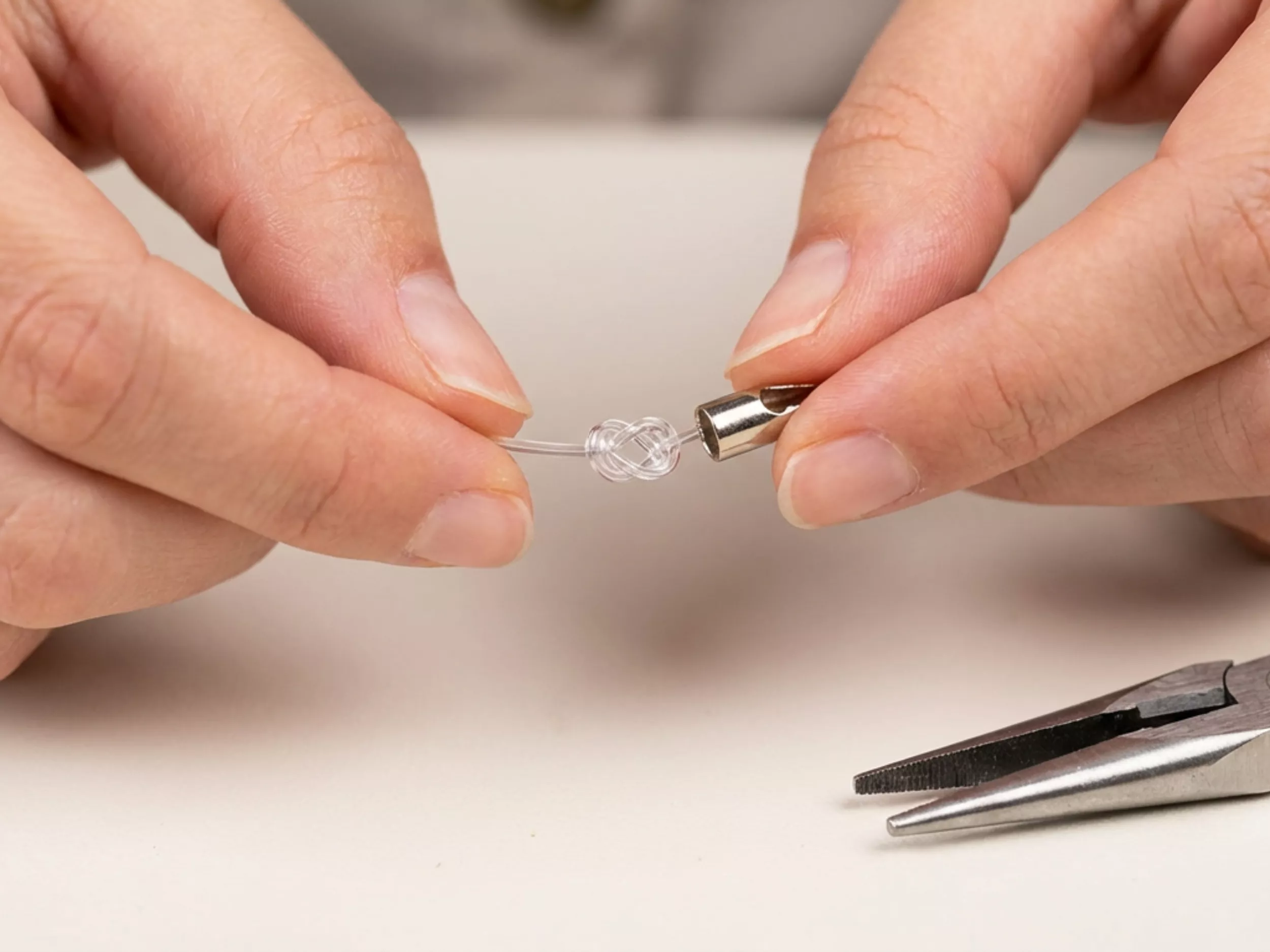 Mãos ajustando um conector em um fio transparente